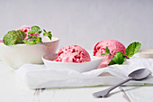 Pink ice cream balls with raspberries and fresh mint