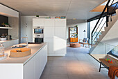 Modern kitchen with island and view of the living room with staircase