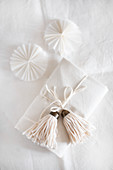 Gift wrapped in white decorated with handmade tassel