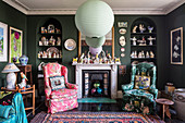 Armchairs in front of fireplace flanked by shelves in niches in living room