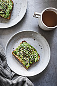 Sliced avocado and sesame seeds on seeded toast