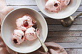 Scoops of cherry ice cream in dessert bowls.