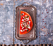 Grilled watermelon with feta cheese, chili pepper and mint on vintage tray