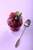 Berries sorbet in glasse (raspberry, blueberry) over on purple background