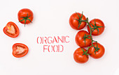 Clean ripe tomato placed near organic food writing on while background
