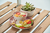 Healthy breakfast with yogurt and assorted colorful fresh fruits served on wooden table