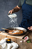 Adding white rice to chopped roasted ingredients on big metal pan