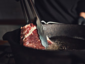 Frying a steak in a pan