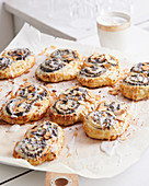 Poppy seed puff pastry buns with icing and flaked almonds