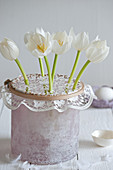 White tulips in vase with lace doily used as flower grid