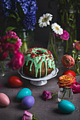 An Easter table laid with a Bundt cake, Easter eggs and flowers