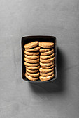 Spelt cookies with almonds in a box on a gray background