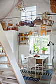Baskets hanging above dining set in rustic white kitchen-dining room