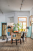 Various chairs around table in dining room with wainscoting