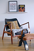 Leopard-print cushion on retro armchair with footstool