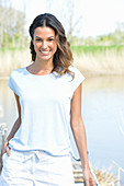 A young woman wearing a light-blue T-shirt and white shorts near river