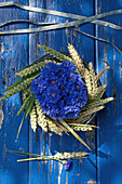 Arrangement of cornflowers in a wreath of wheat ears