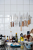 Magnetic knife rack on tiled wall in kitchen
