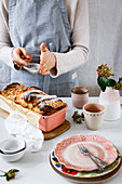 Pull-apart quark bread with rhubarb being dusted with icing sugar