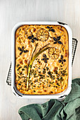 Sourdough focaccia with a flower picture made of herbs, spring onions and garlic