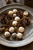 Festive arrangement of embroidered felt balls and pine cones