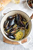 A pot of cooked mussels mit wine sauce