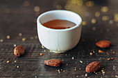 A bowl of honey surrounded by almonds