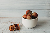 Hazelnuts in a bowl with a walnut next to it
