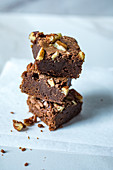 A stack of three brownies with nuts