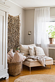 Fur blanket on easy chair below wall hanging in Bohemian-style living room