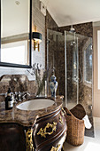 Opulent, Baroque washstand with stone top in classic bathroom