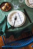 Teller mit blauem Karomuster auf dem Tisch mit grüner Tischdecke
