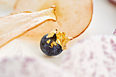 A blueberry with gold leaf as a cake decoration