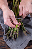 A man peeling green asparagus