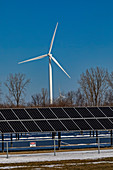 Wind farm and solar panels in snow, Michigan, USA