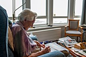 Care home resident doing a crossword puzzle