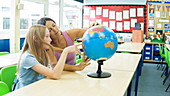 School girl and teacher with globe