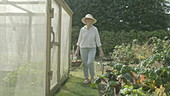 Woman walking though garden, slo mo