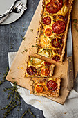 A colourful tomato quiche with thyme, sliced