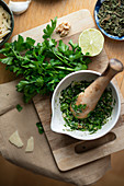 Pesto Verde mit Petersilie und Minze im Mörser zubereiten