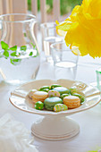 Macarons und bemalte Mini-Ostereier auf frühlingshaftem Ostertisch