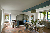 Dining table and terracotta floor tiles in rustic country-house kitchen
