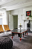 Antique table and modern chairs in front of wood-burning stove