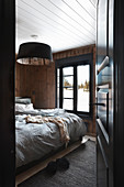 View through open panelled door into rustic bedroom