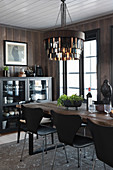 Leather-fringed lampshade above dining table and designer chairs