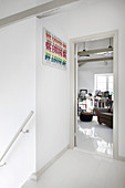 White landing with view of bookcase and armchair in study