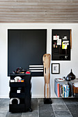 Eames' Leg Splint sculpture, black pinboard and trolley in study