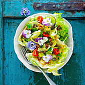A mixed leaf salad with tomatoes, capers and flowers