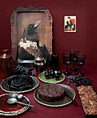 Kuchenbuffet und Tablett mit Vogelmotiv vor roter Wand