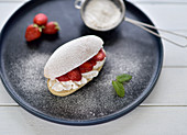 Vegan brioche bun, filled with vegan cream and fresh strawberries